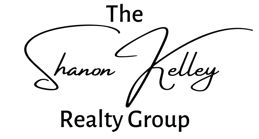 The logo of the Shanon Kelley Realty Group is displayed with a subtle back shadow effect. The logo features the name "Shanon Kelley Realty Group" written in a clean and modern font, with each word stacked on top of one another. The letters are solid and well-defined, creating a professional and legible appearance.