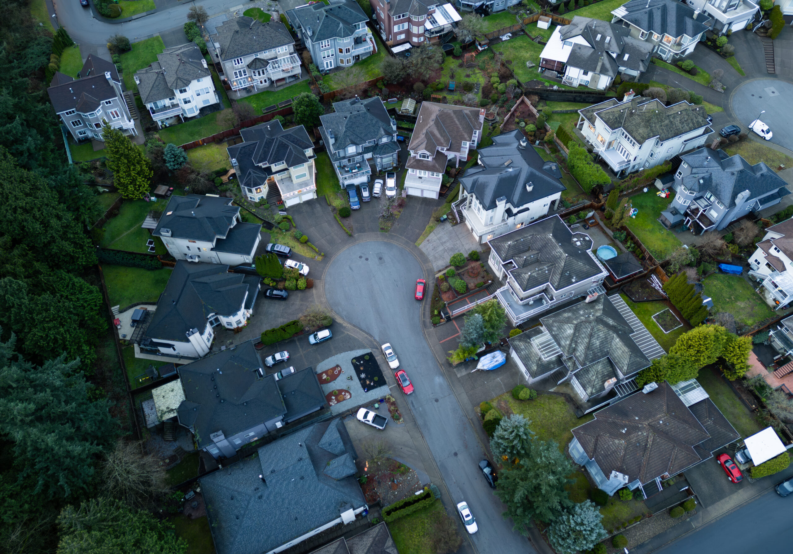 Panoramic aerial view showing houses, a cul-de-sac, and green spaces in a neighborhood